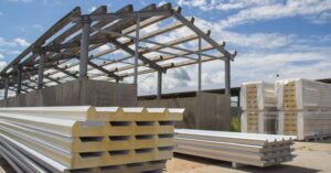 Workers assembling PUF panels for construction, ensuring energy-efficient and sturdy structures.